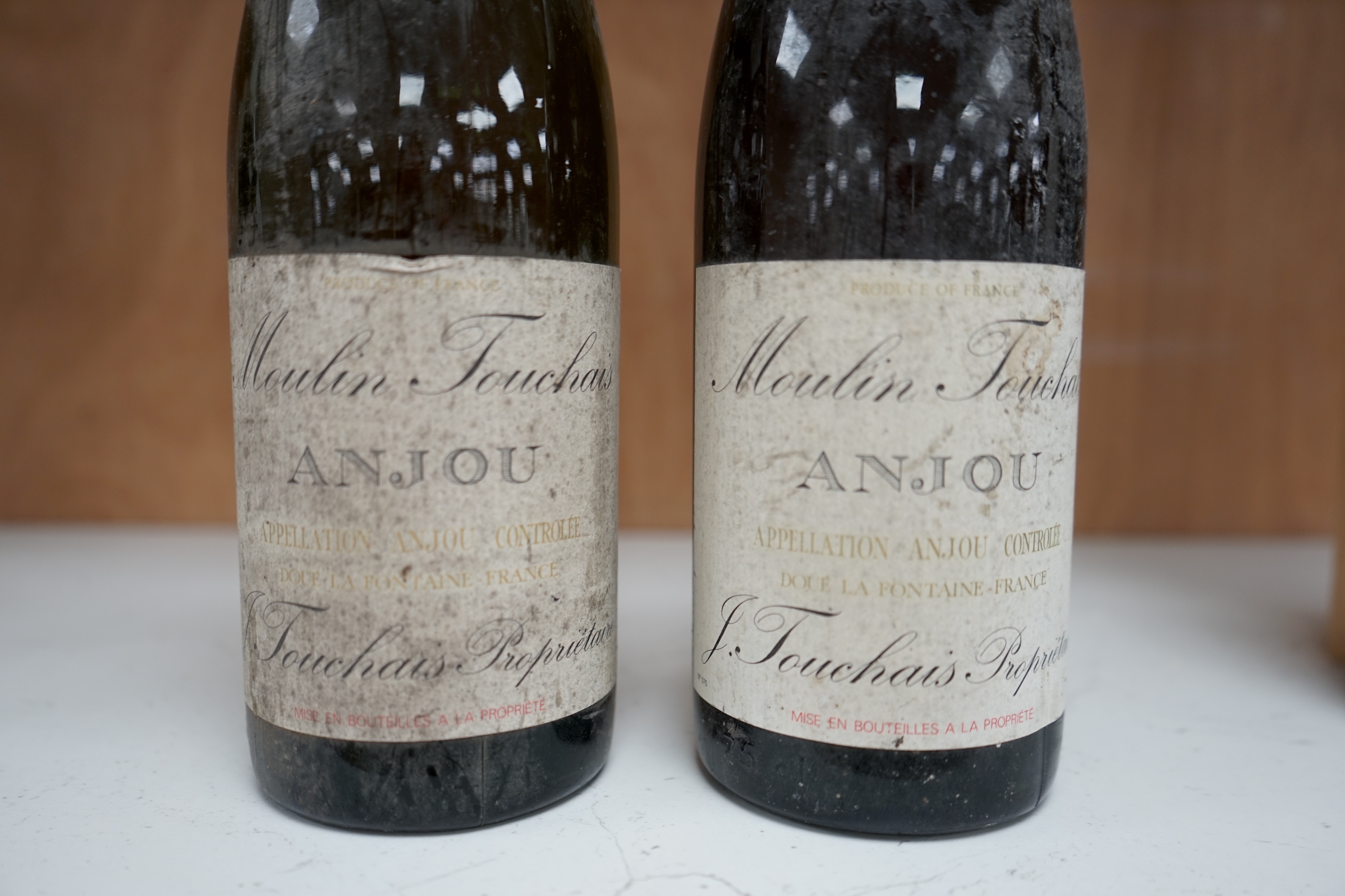 Two bottles of Moulin Touchais Anjou 1959 red wine. Condition - fair, staining to label, etc.